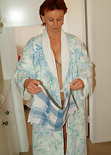 Redheaded MILF with a hairy pussy leaves her bathrobe undone
