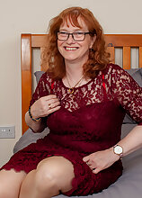 Naughty mature lady playing with her pussy in bed